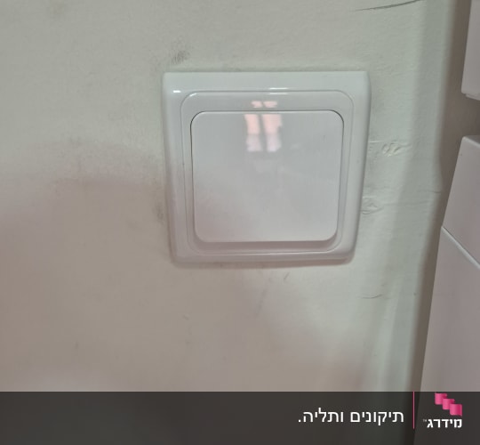מתג חשמל על קיר לבן